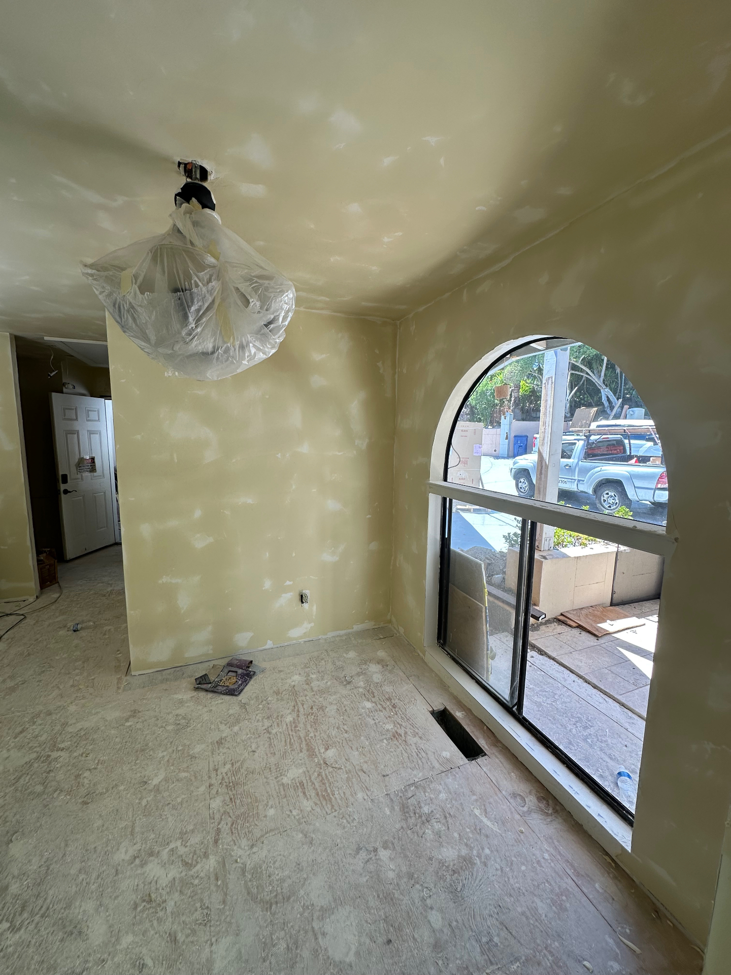 Interior room with freshly taped and mudded drywall around an arched window