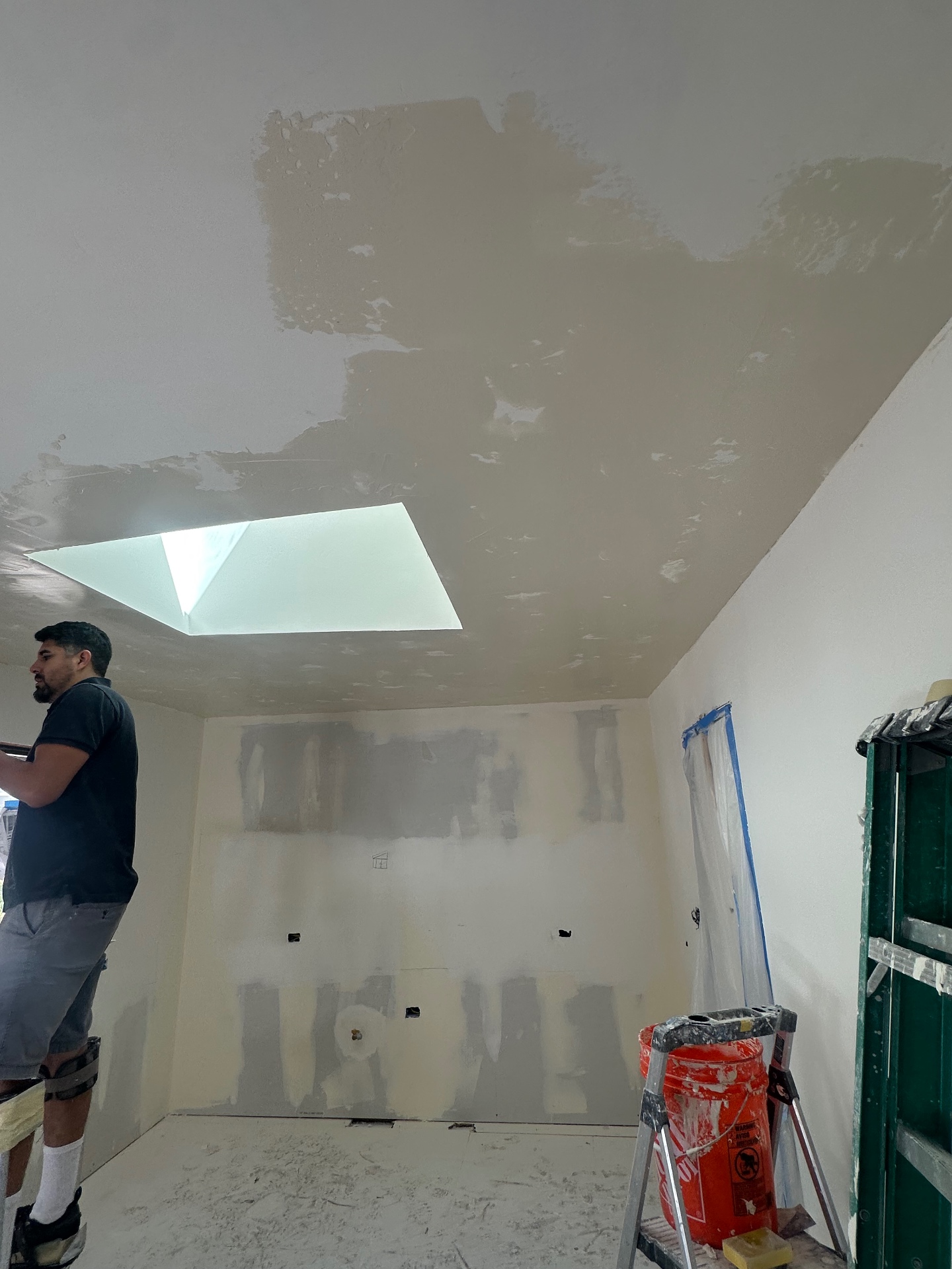 JMF Builders craftsman finishing a drywall ceiling around a skylight